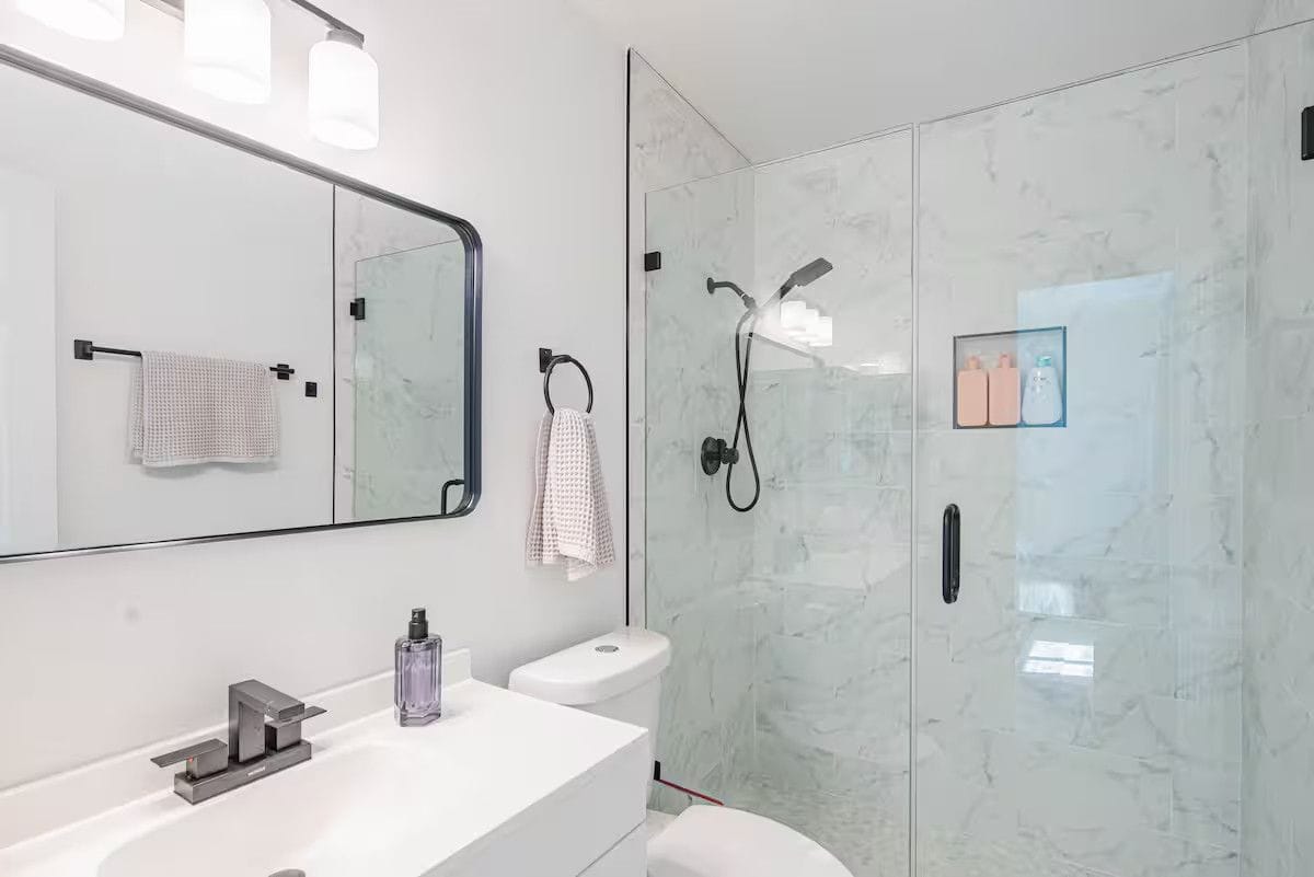 Second bathroom after a turnover: streak-free glass shower, polished fixtures, fresh waffle towels hung