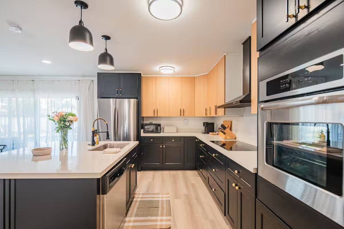 Kitchen after a turnover: cleared quartz counters, polished stainless appliances, sink wiped dry