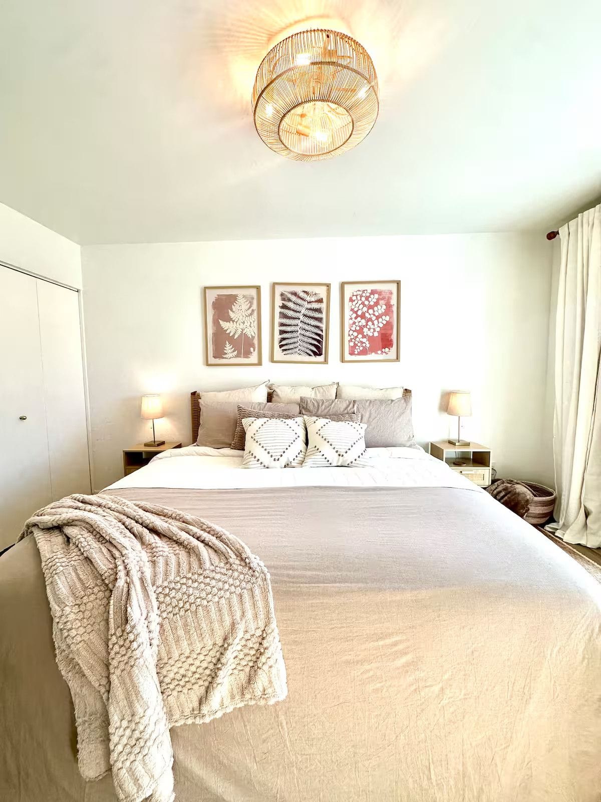 Master suite with a freshly made king bed, crisp linens, styled pillows and a folded throw